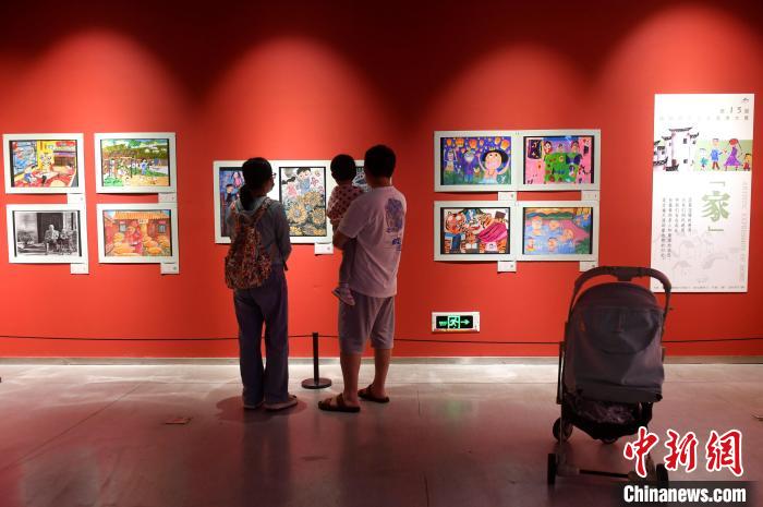 图为家长带着孩子参观展览。　吕明 摄