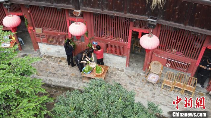 村民在土楼内忙着包粽子。 永定土楼景区供图 村民在土楼内忙着包粽子。 永定土楼景区供图