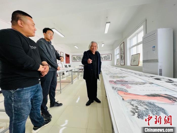 图为张振生与书法爱好者探讨《三百六十行祖师爷》人物故事。　郑晨子 摄