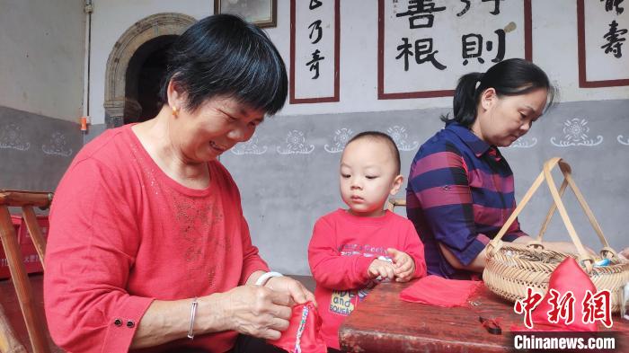 村民将艾草装进布包。 永定土楼景区供图 村民将艾草装进布包。 永定土楼景区供图