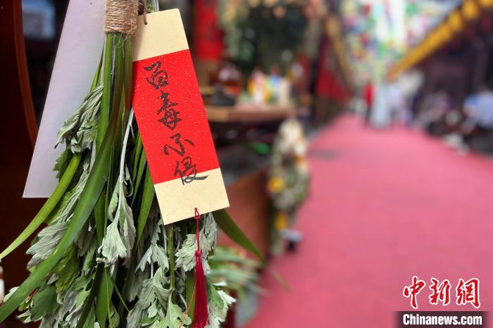 秭归人在家门口挂艾草祈福家人身体健康。　郭晓莹 摄
