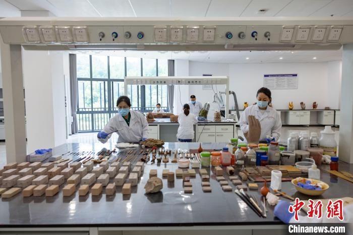 图为文物保护修复人员开展工作。　大足石刻研究院供图