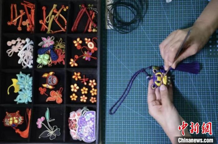 张丽娟正在给服饰手工滚边。　陈璐 　摄