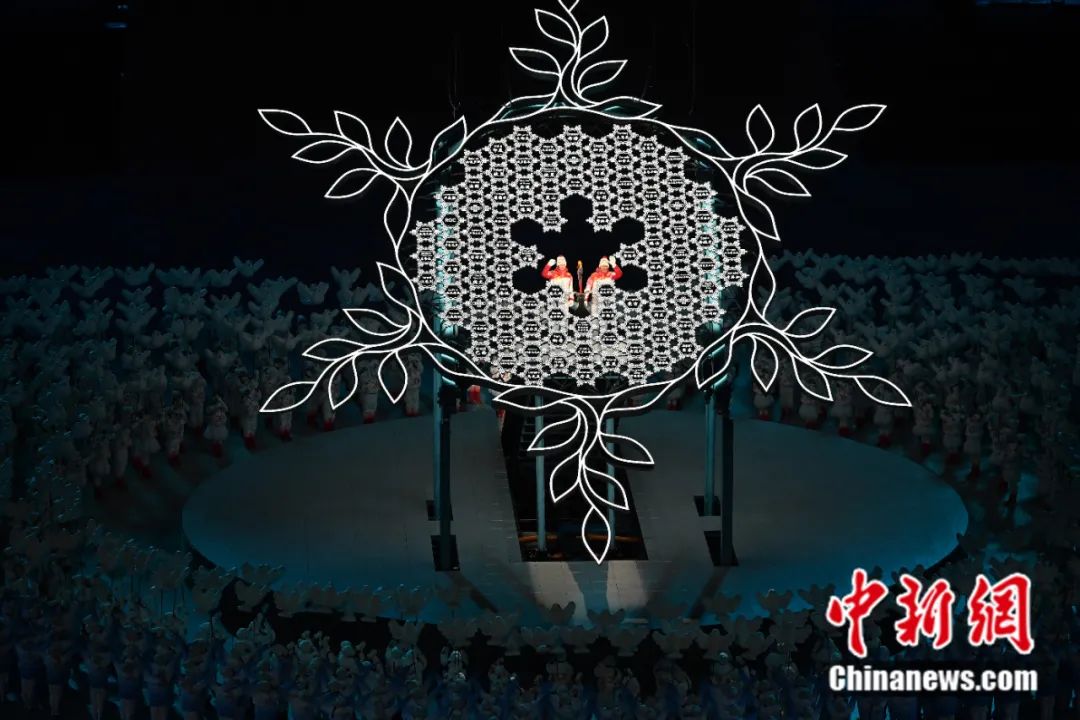2022年2月4日晚，第二十四届冬季奥林匹克运动会开幕式在北京国家体育场举行。图为迪妮格尔-依拉木江和赵嘉文将最后一棒火炬留在“大雪花”中心。<a target='_blank' href='/'>中新社</a>记者 毛建军 摄
