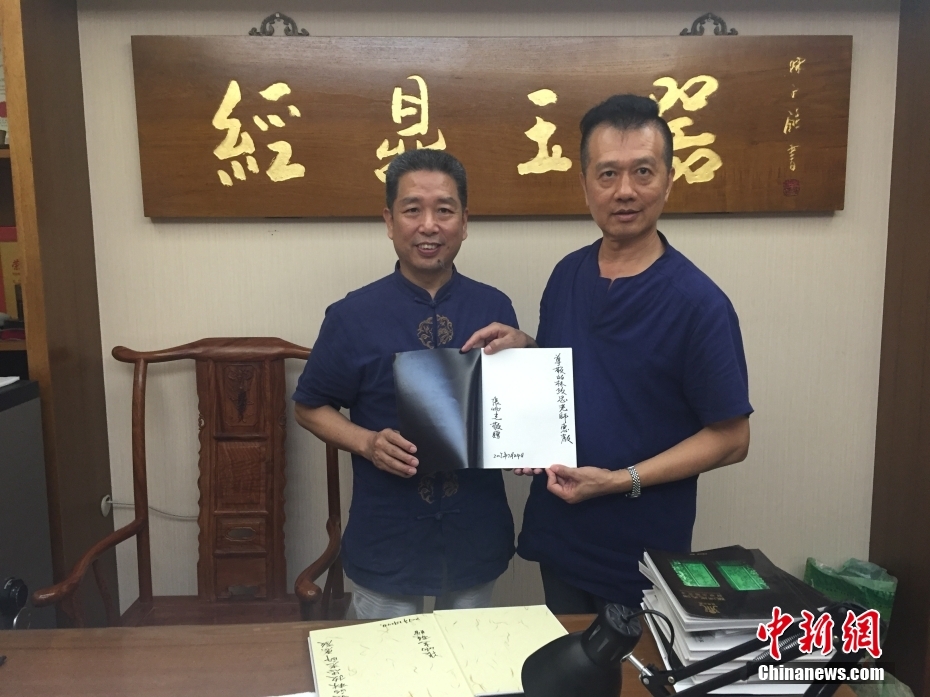 资料图为2017年7月24日，林政忠（右）与中国工艺美术大师张炳光（左）交流，并获赠其作品图录。 <a target='_blank' href='/'>中新社</a>发 受访者 供图