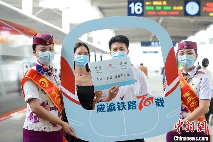 7月1日是成渝铁路开通运营70周年。作为新中国成立后建成的第一条铁路，中国西南地区第一条铁路干线，成渝铁路见证了成渝两地交通、经济的飞速发展。图为旅客在重庆北站站台与“成渝铁路70载”的纪念展板合影留念。 <a target='_blank' href='/'>中新社</a>记者 何蓬磊 摄