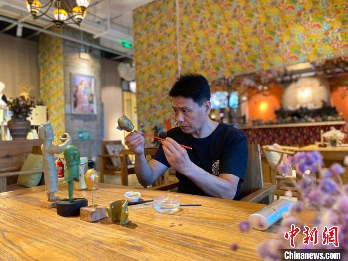 尹吉明正在制作面塑版纵目面具。　何佳林 摄