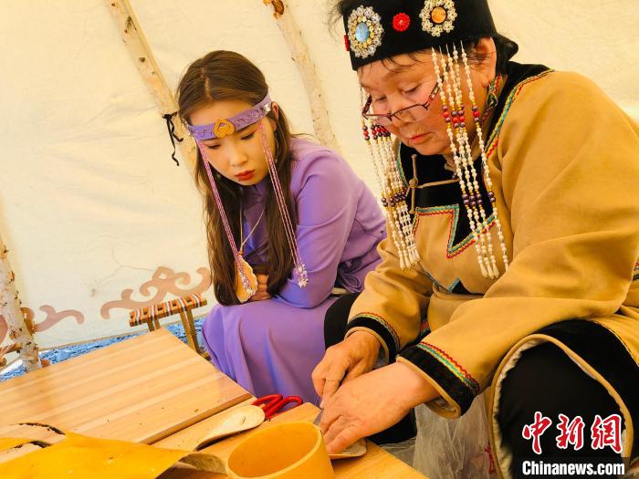 图为吴琼跟着葛色荣老人学习桦树皮制作技艺。　张玮 摄