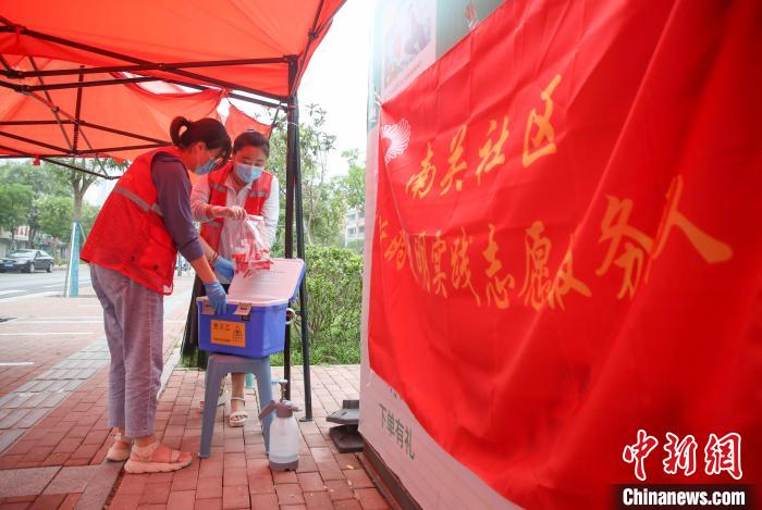 7月11日,山东省临沂市兰山区一处核酸检测点,社区志愿者正在收集刚刚采集到的核酸检测样本。 许传宝 摄 7月11日,山东省临沂市兰山区一处核酸检测点,社区志愿者正在收集刚刚采集到的核酸检测样本。 许传宝 摄