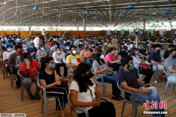 资料图：印度民众排队等待接种新冠疫苗。