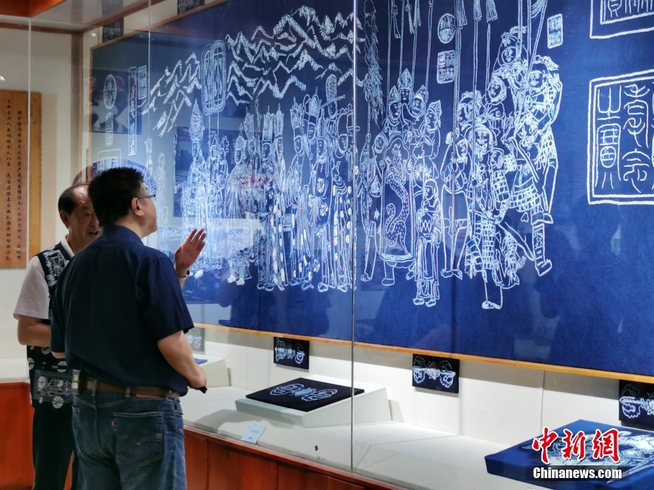 7月12日，2022云台文化寻宝活动走进云南大理，寻访迁台文化瑰宝《张胜温画卷》的前世今生。图为台湾中国文化大学教授邱毅（右）与当地非物质文化遗产传承人、文博专家共赏白族扎染版《张胜温画卷》。 <a target='_blank' href='/'>中新社</a>记者 胡远航 摄