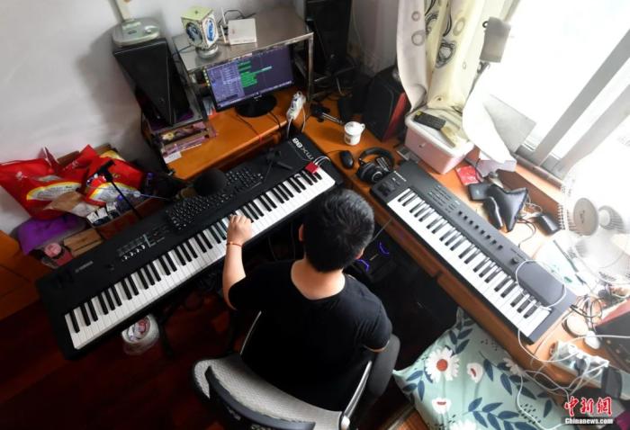 图为7月3日,黄延平正在编曲。不到8平米的房间即是他的工作室,也是他的卧室。吕明 摄 图为7月3日,黄延平正在编曲。不到8平米的房间即是他的工作室,也是他的卧室。吕明 摄